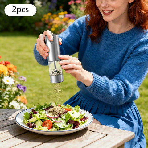 Touch Activated Automatic Electric Spice Grinder With Soft Glow LED Light Salt And Pepper Mill For Kitchen Countertop in use over salad.