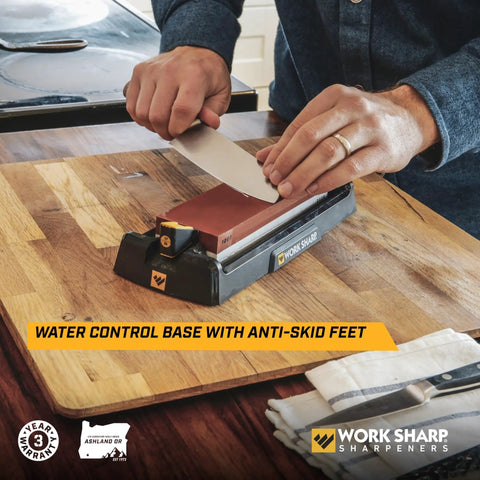 Pro Grade Kickass Benchtop Whetstone Knife Sharpener With 1000/6000 Grit Corundum Stones on a wooden counter, person sharpening knife