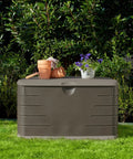 Beefy 73 Gallon Resin Outdoor Storage Deck Box Weather Resistant Brown in garden setting with plants on top