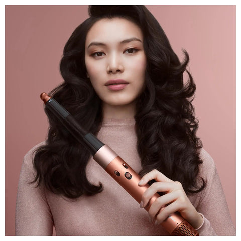 Model holding Airwrap I.D. Multi Styler 6-In-1 Hair Tool With App Control And Bluetooth Connected, showcasing voluminous curls.