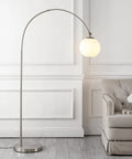 Nickel And White Nora Arc Floor Lamp With Mercury Glass Shade standing next to a sofa in a living room