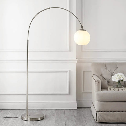Nickel And White Nora Arc Floor Lamp With Mercury Glass Shade standing next to a sofa in a living room
