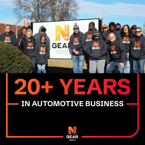 Team standing in front of Nth Gear sign, celebrating 20+ years in automotive business.