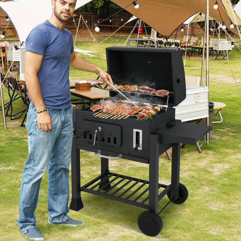 Man grilling on Barrel Charcoal Grill With Side Tables And Wheels, 544 Sq In Total Cooking Space, Portable Outdoor BBQ On Wheels