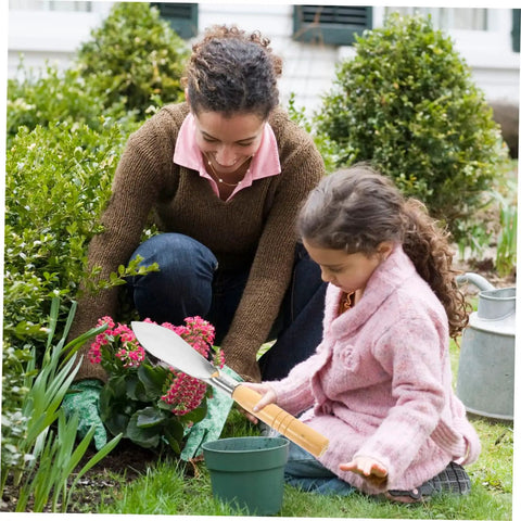 Child using Ergonomic Hand Shovel for Gardening, No-Fuss Grip, Dig Deep Spade for Planting in a garden with a parent watching.