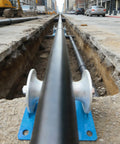 Beefy Heavy Duty Cable Puller Sheave For Large Scale Laying Industrial Pipe Feeding Pulley visible in urban trench.