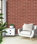 Living room with Dope Red Faux Brick Wall Tiles 100 Pack 3D Thin Brick Veneers, white armchair and plant, modern decor