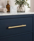 Heavy Duty 5 Pack Solid Brass Cabinet Pulls With Brushed Gold Finish, 5in handle on navy drawer with marble countertop.