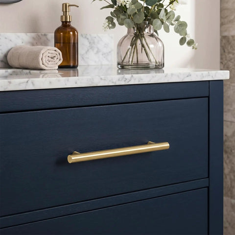 Heavy Duty 5 Pack Solid Brass Cabinet Pulls With Brushed Gold Finish, 5in handle on navy drawer with marble countertop.