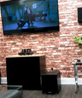 Living room setup with Shaker 8 Inch Powered Subwoofer With 400W Peak 200W RMS Class D Amplifier Deep Bass, TV mounted on brick wall.