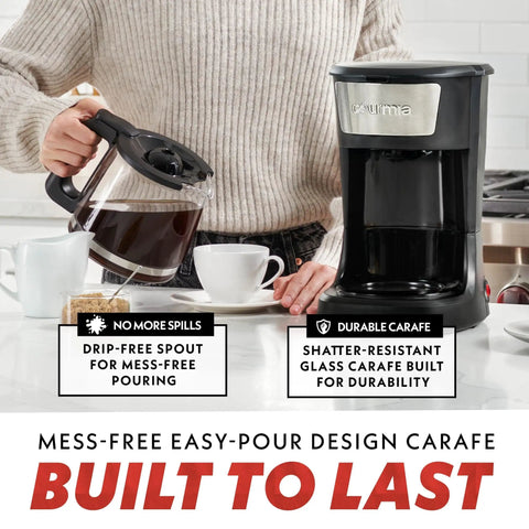 Person pouring coffee from 12 Cup One Touch Coffee Maker With Pause And Serve Automatic Keep Warm Easy View Water Window Compact Stainless Steel Accents Black Finish No Fuss Fast Brew For Solo Mornings Or Busy Family Breakfasts into a cup, showing drip-free spout and durable carafe.