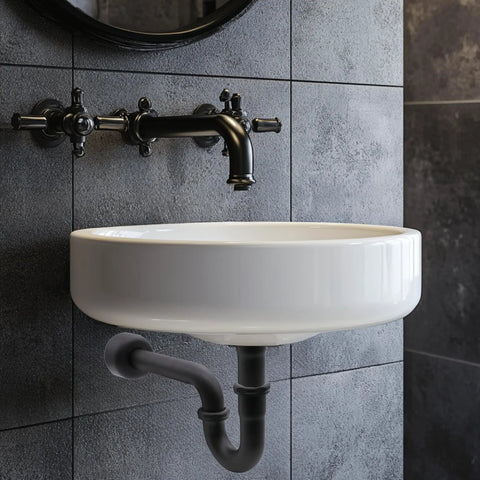 One And A Half Inch OD 17 Gauge Brass P-Trap With High Box Flange Matte Black Finish installed under a wall-mounted sink