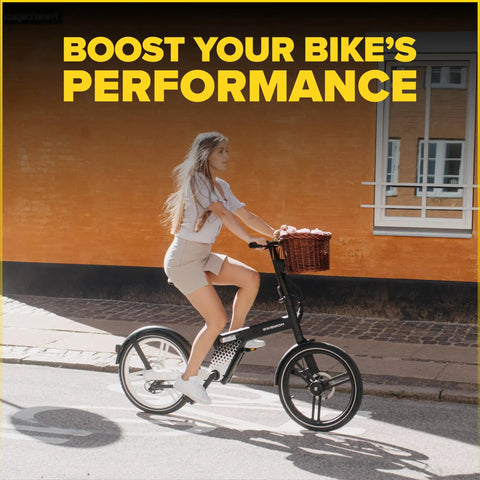 Woman riding a bicycle by a brick wall, basket in front