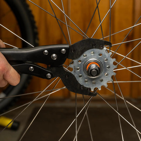 Vise Whip II Cassette Removal Tool For Bikes shown gripping a sprocket on a bicycle wheel, heat treated steel, easy release jaws.
