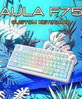 Badass Wireless Mechanical Gaming Keyboard With Dope Creamy Switches And Smooth Volume Knobs Features Tri Mode Bluetooth And Usb C Wired Connect For Gamer Desk Setup against a tropical background.