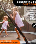 Two young girls playing on a trampoline, outdoors, with sunlight filtering through trees, showcasing the joy of outdoor play.
