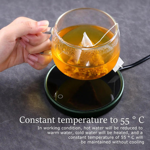 Electric Mug Warmer And Cooler For Desk keeps tea at 55°C on a black thermal pad, held in hand, ideal for focused work.