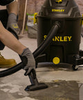 Person using 10 Gallon Wet Dry Shop Vacuum with 6 Peak HP Motor and Built In Drain for water cleanup on concrete floor.