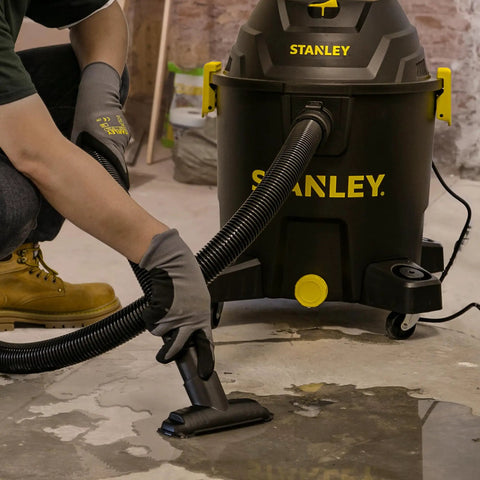Person using 10 Gallon Wet Dry Shop Vacuum with 6 Peak HP Motor and Built In Drain for water cleanup on concrete floor.