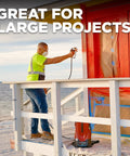 Man using Tough As Nails 18V Cordless Airless Paint Sprayer With Advanced HEA Tech for large project on wooden structure.