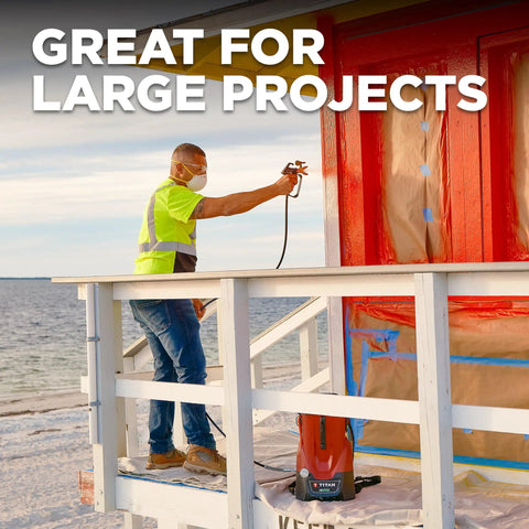 Man using Tough As Nails 18V Cordless Airless Paint Sprayer With Advanced HEA Tech for large project on wooden structure.