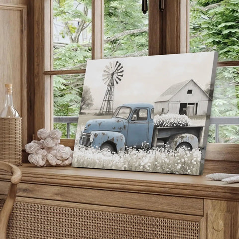Rustic Countryside Barn Canvas Wall Art Featuring Blue Rusty Old Pickup Truck, White Flower Meadow, Windmill and Barn Backdrop For Farmhouse Decor, Vintage Country Vibe Print, 24x16 Inches displayed indoors