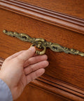 Hand holding Vintage Bronze Long Drawer Pulls Old School 4 Pack With Screws 200mm Length on wooden dresser