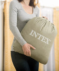 Super Thick Twin Air Mattress With Built In Pump And Roll Up Travel Bag, gray travel bag held by a person.