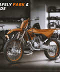 Beefy Heavy Duty Triangle Motorcycle Stand Universal Kickstand For 80 To 500cc Dirt Bikes in garage with orange motocross bike