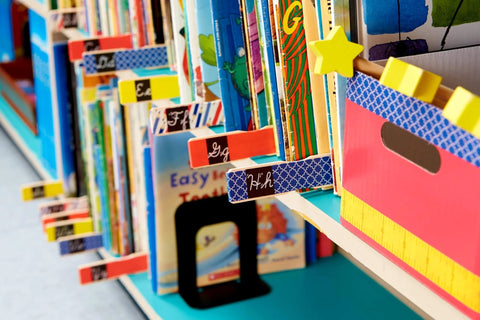 Colorful bookshelf with books labeled using Fun Dots Washi Tape 6-Roll Set, .59 in x 393 in Decorative Craft and Planner Tape.
