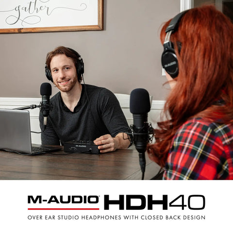 Two people podcasting wearing Dope Over Ear Studio Headphones With Closed Back Design, microphones and laptop on table.