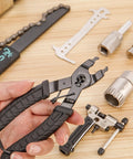 Detail of 7 Piece Bike Tool Kit With Storage Case For Mountain And Road Bikes, including chain rivet extractor and pliers on wood surface
