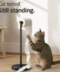 Cat interacting with freestanding matte black toilet paper holder stand, rustproof SUS304 stainless steel with heavy 3 lb base for stability.