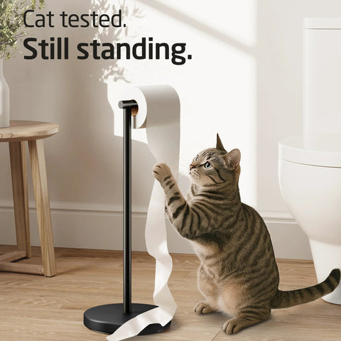 Cat interacting with freestanding matte black toilet paper holder stand, rustproof SUS304 stainless steel with heavy 3 lb base for stability.