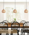 Top Tier Hand Woven Wicker Pendant Lights Trio Boasts A Natural Rattan Dome Shell with adjustable wires in a dining space.