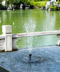 Sun Powered Solar Bird Bath Fountain Pump With 6 Nozzles creating water feature in outdoor garden pond setting