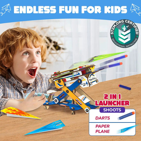 Boy playing with 2in1 Hydraulic Paper Airplanes and Darts Launcher STEM Toy for Kids Ages 6 to 14 Easy DIY Build Kit on table.