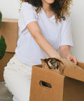 Person packing with Brown Kraft Packing Paper Sheets For Moving And Shipping 1500 Count 1375 Feet Total in a cardboard box.