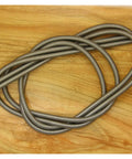 Two Pack Long Flexible Compression Springs 0.8mm Wire Diameter, 5 To 14mm Outer Diameter, 1000mm Length coiled on a wooden surface