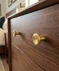 Top Shelf Unlacquered Brass Cabinet Knobs Straight Up Modern Round Dish Hardware Featuring Live Patina Finish 1.18 Inch Face Width For A Cool Kitchen Revamp Two Pack Bundle on wooden dresser.