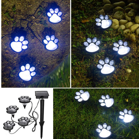 Dog And Cat Paw Print Solar Lights Set Of 4 For Outdoor Pathway Waterproof Paw Path Lights glowing on garden path at night.