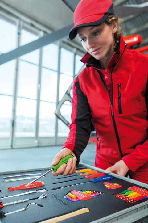Person organizing Swiss Grip Starby Coin Driver With Red Handle, 45 mm Shaft, 100 mm Total Length in tool case.