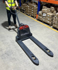Heavy Duty Mechanics Electric Pallet Jack With 3300 Lbs Lift Capacity And Removable Lithium Ion Battery For Smooth Warehouse Operations in a warehouse.