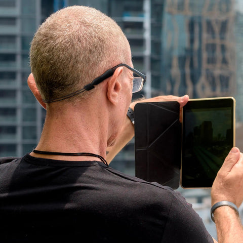 Man wearing No Tail Eyewear Strap For Glasses, Adjustable Retainer Lanyard With Silicone Tips outdoors, holding a tablet