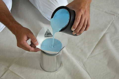 Person pouring blue paint through Cone Strainer Set, Medium Mesh 226 Micron, 1000 Count White, into a metal container.