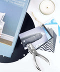 Circle Hole Punch Set Two Piece One Eighth Inch And One Quarter Inch Single Hole Punchers for crafts next to photos and candle