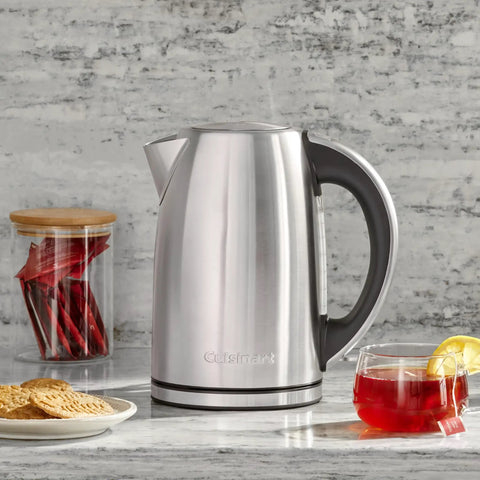 Stainless Steel Electric Kettle 1.7 Liter Cordless Design With 1500 Watt Power For Fast Boiling Tea Coffee And Hot Chocolate next to tea and cookies.