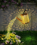 Solar Garden Watering Can With Lights cascading golden glow over flowers in a lawn; Outdoor Hanging Lanterns.