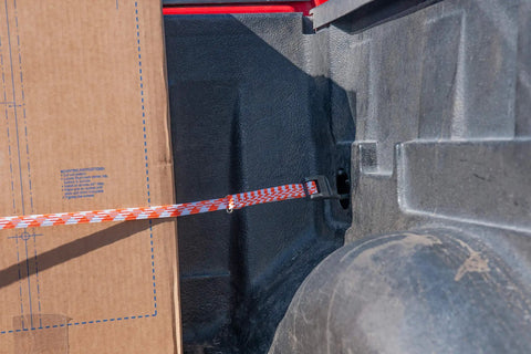 All Weather Must Have Adjustable Flat Bungee Cord From 10 In To 54 In Stretch Multicolor Tie Down securing a box in truck bed