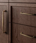 Close-up of Killer Vintage Antique Brass Cabinet Handles Slick Zinc Alloy Pulls on dark wood cabinet drawers.